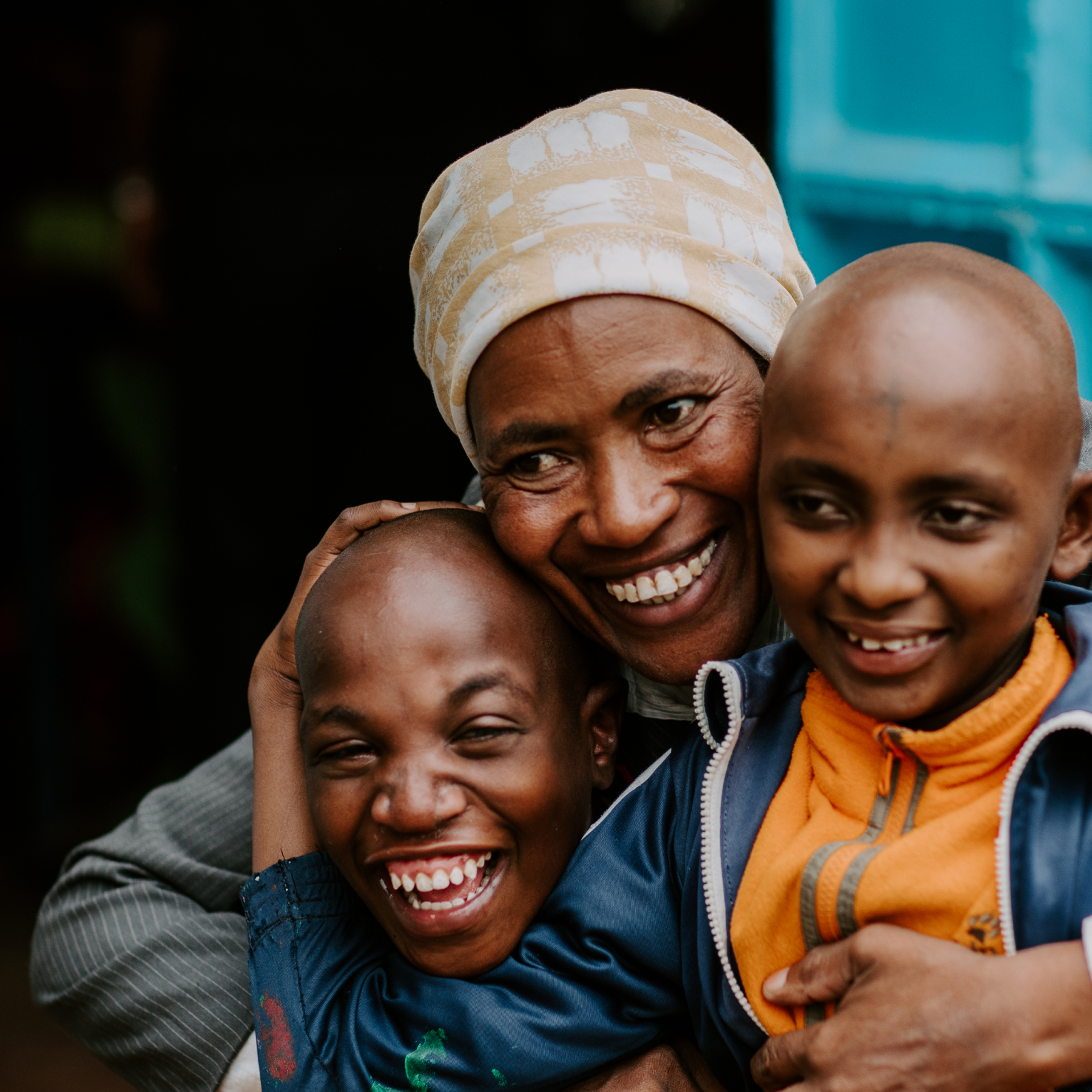 Woman hugging and smiling with 2 kids